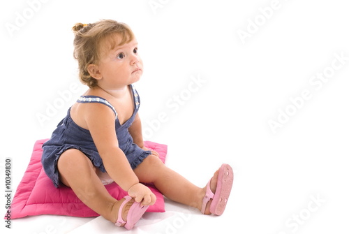 Cute Baby sitting in the pink pillow .