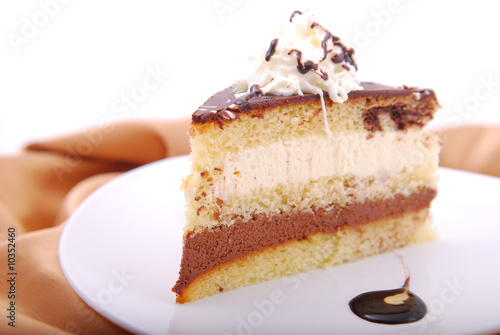 Mousse cake on a white plate garnished with chocolate