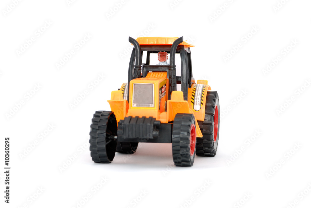 Toy tractor isolated. Focus on a cabin and the driver