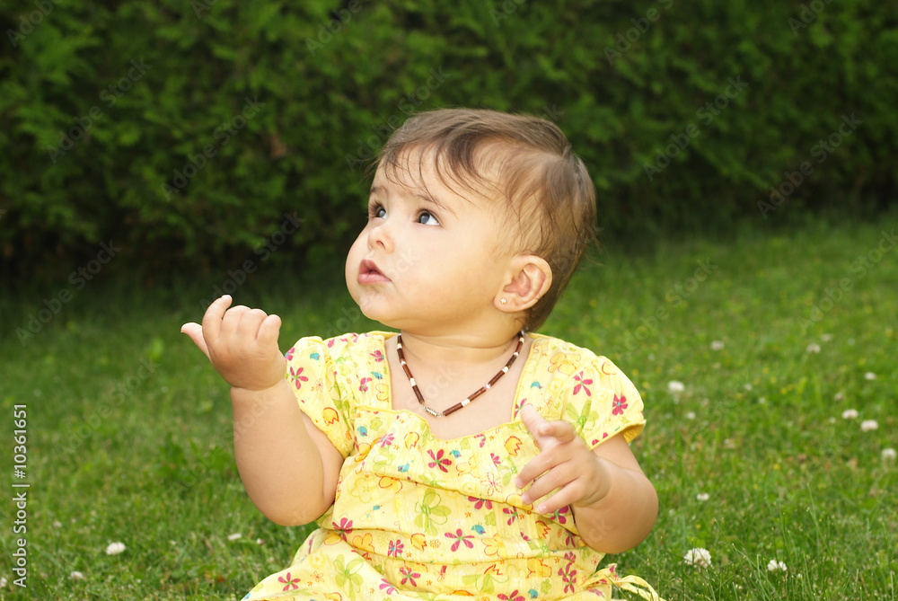 baby girl with a yellow dress sitting on the grass baby girl with a yellow dress sitting on the grass