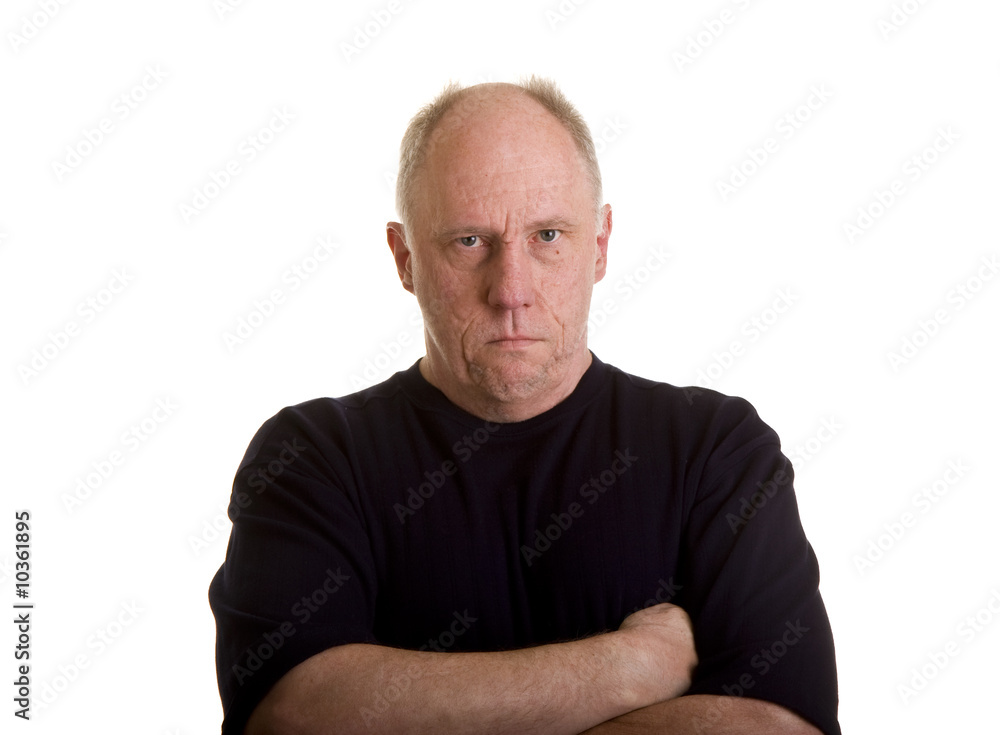An older bald man in a black shirt looking angry or mad An older bald man in a black shirt looking angry or mad