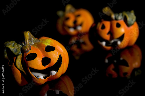 Pumpkins, autumnal leaves ad ghosts on a black