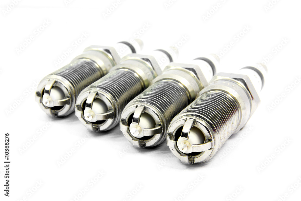 Detail view of an engine spark plugs over white background. Detail view of an engine spark plugs over white background.