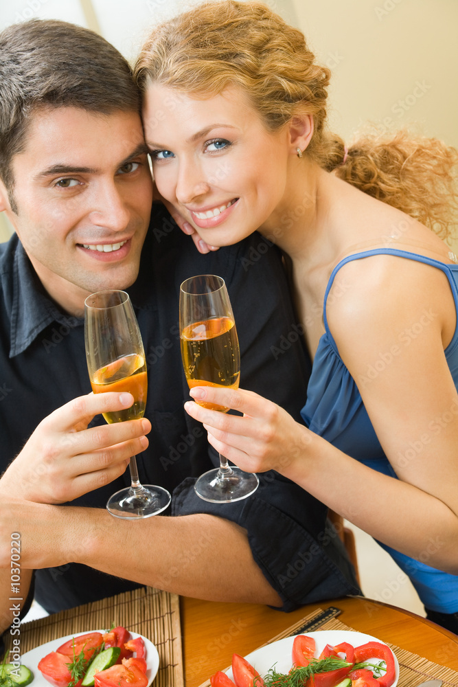 Young couple celebrating with champagne at home