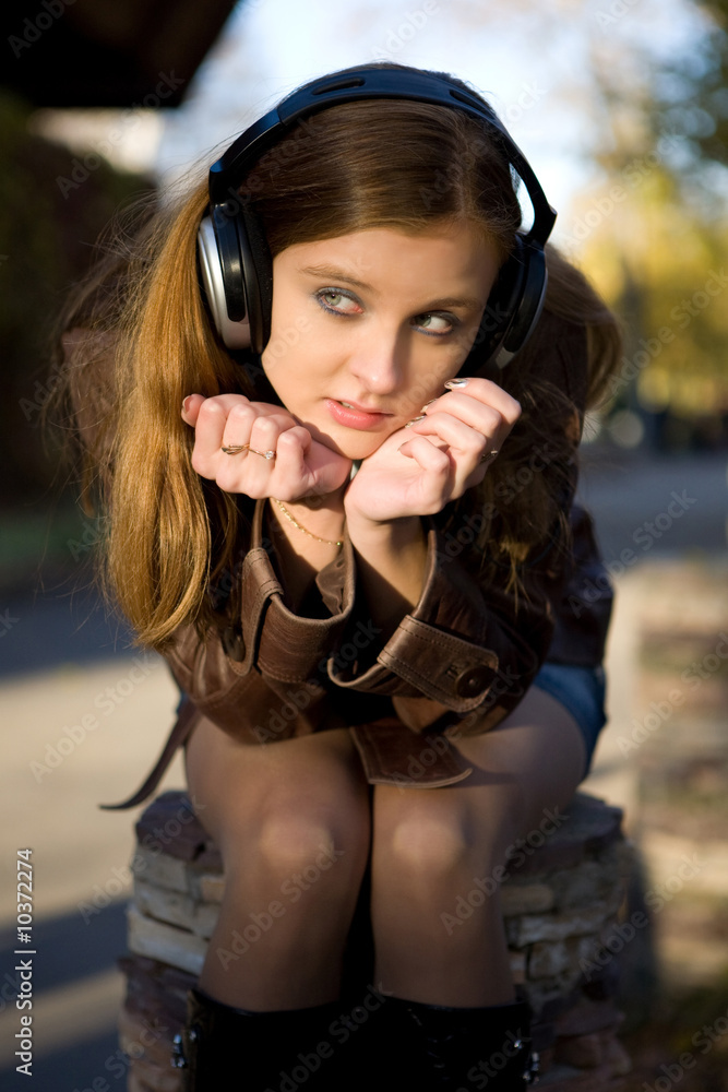 Pretty girl in headphones on the street background Pretty girl in headphones on the street background