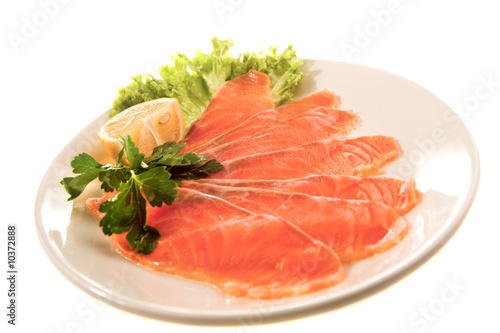 red fish slices with lemon and lettuce