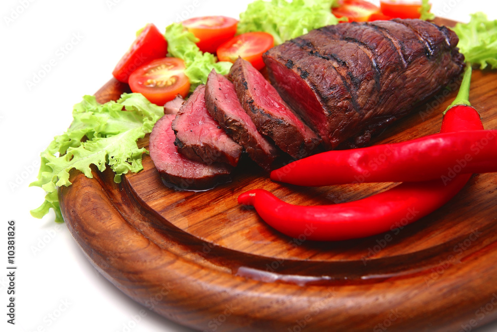 red roast meat served on wooden plate with vegetables red roast meat served on wooden plate with vegetables