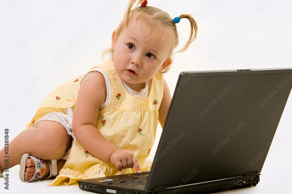 Adorable baby girl in pigtails working on a laptop computer Adorable baby girl in pigtails working on a laptop computer