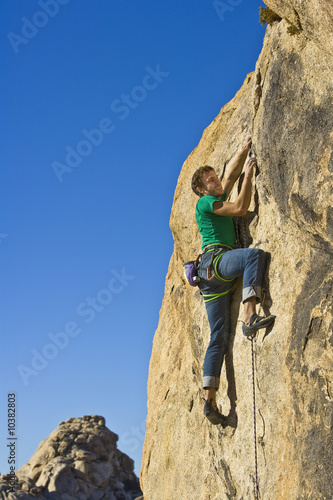 Climber ascending a steep rock face.