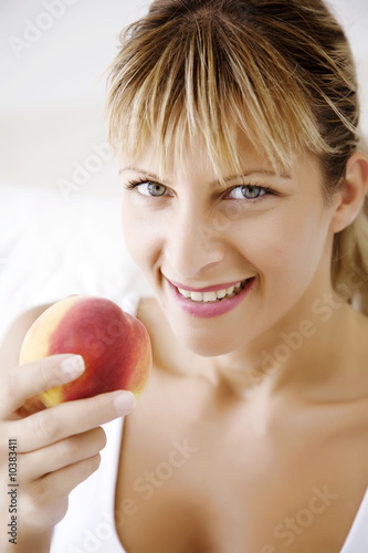 happy female ating peach photo