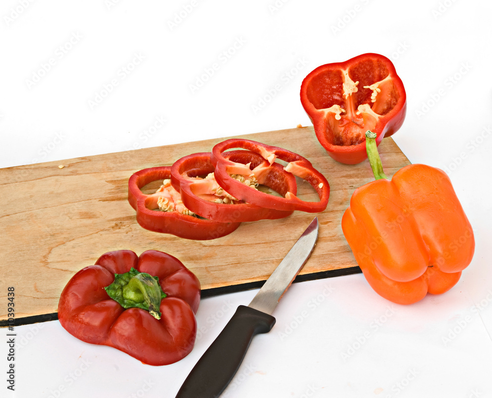 Sweet peppers being chopped on a wooden broad Sweet peppers being chopped on a wooden broad