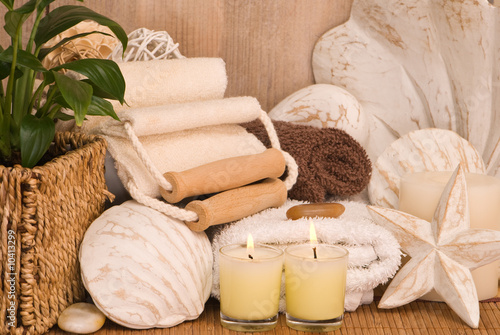 Towels with seashells and candles in spa setting