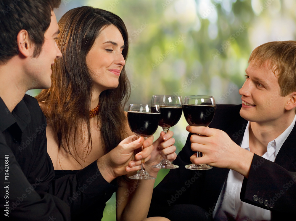 Two young men flirting with woman at celebration or party Two young men flirting with woman at celebration or party