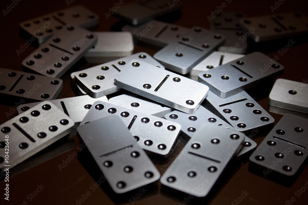 Steel dominoes on a polished surface in a spot light Steel dominoes on a polished surface in a spot light