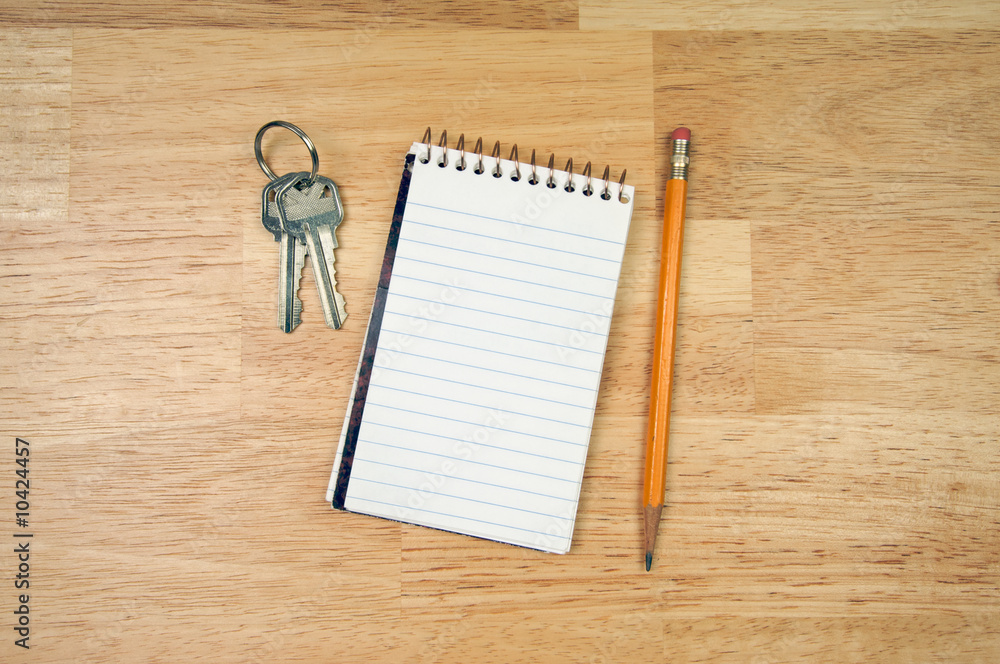 Pad of Paper, Pencil and Keys on a Wood Background. Pad of Paper, Pencil and Keys on a Wood Background.