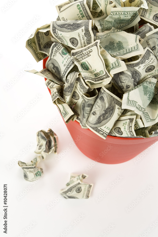 Dollars in Red Garbage Can with White Background Dollars in Red Garbage Can with White Background