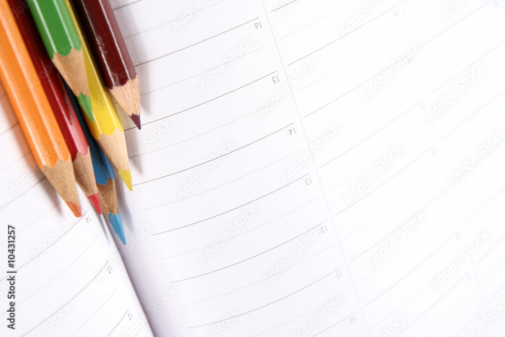 Close-up of color pencils and agenda Close-up of color pencils and agenda