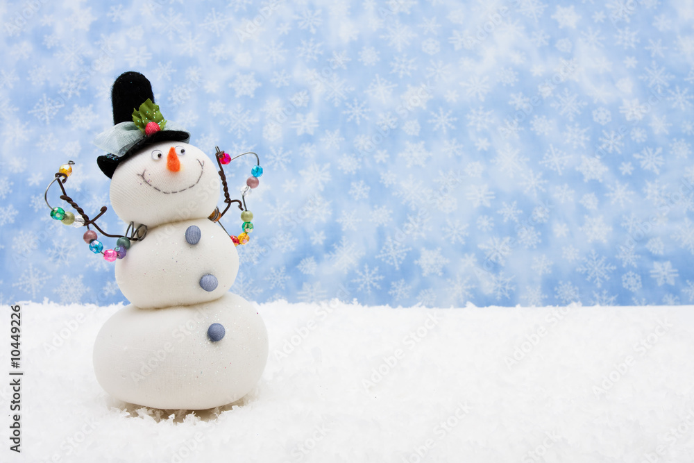 Snowman sitting on snow with snowflake background