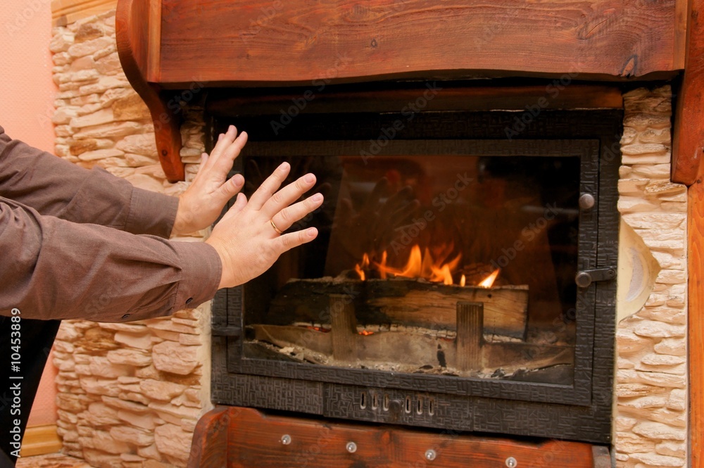 man warming hand at fireplace