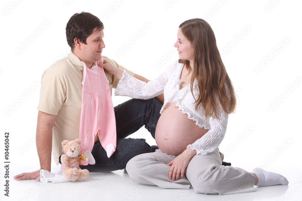 Couple waiting for baby sitting and looking on baby clothes