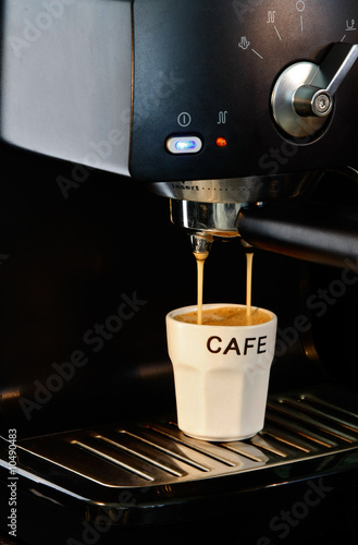 Machine à café remplissant une tasse. photo