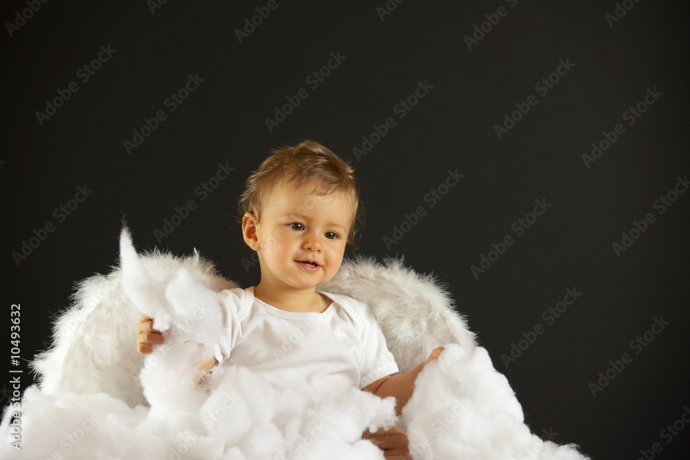 baby girl with angel wings sitting in soft white batting baby girl with angel wings sitting in soft white batting
