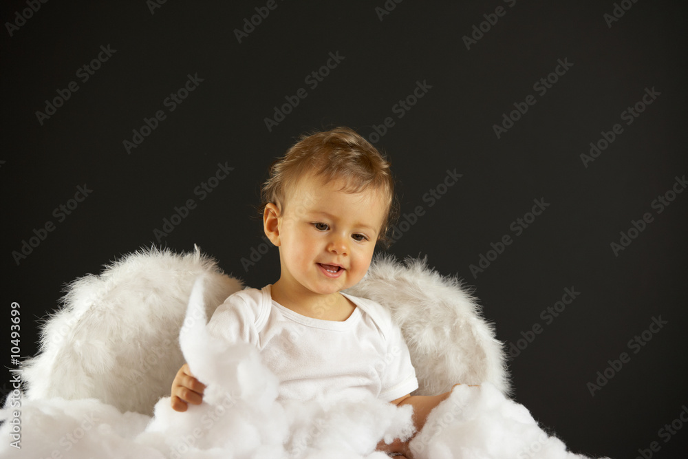 baby girl with angel wings sitting in soft white batting baby girl with angel wings sitting in soft white batting