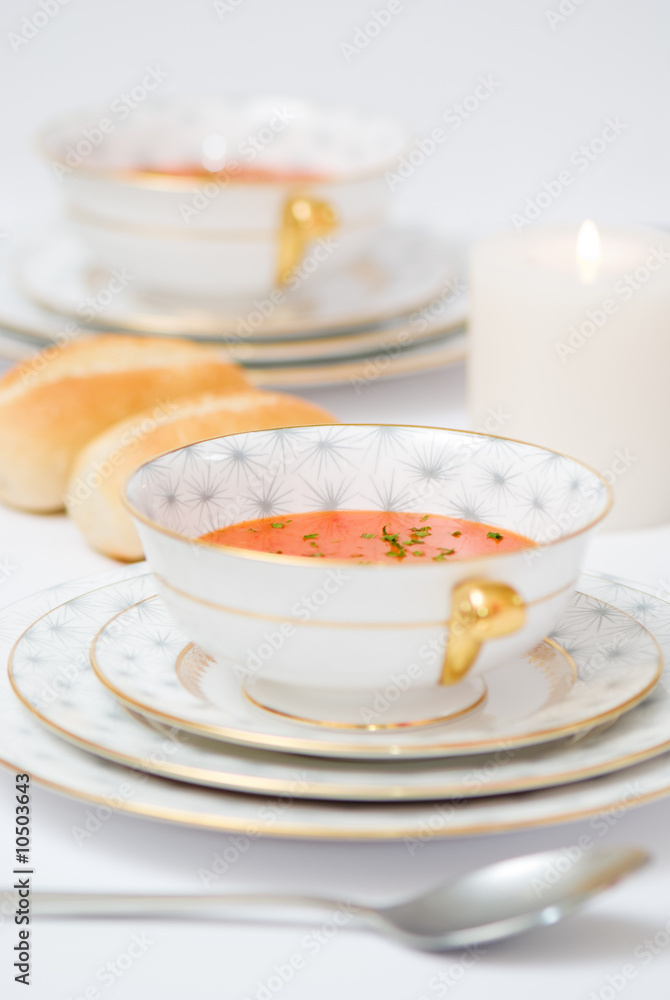 Dinner table set with tomato soup hors d'oeuvre Dinner table set with tomato soup hors d'oeuvre