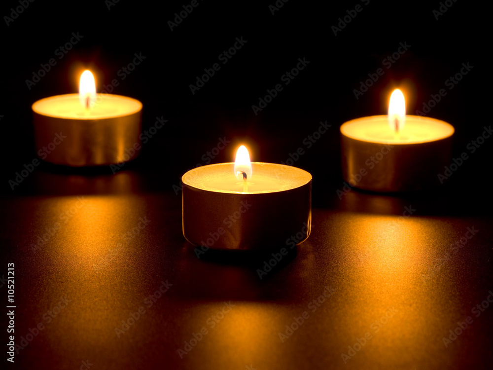 Three burning candles isolated on black background Three burning candles isolated on black background