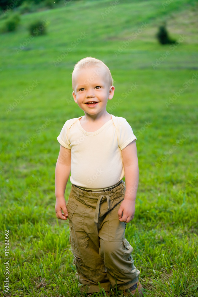 Portrait of smiling little boy on sunny green grass field Portrait of smiling little boy on sunny green grass field