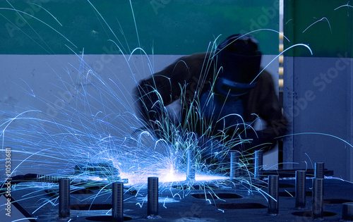 welding worker with sparks arcing photo