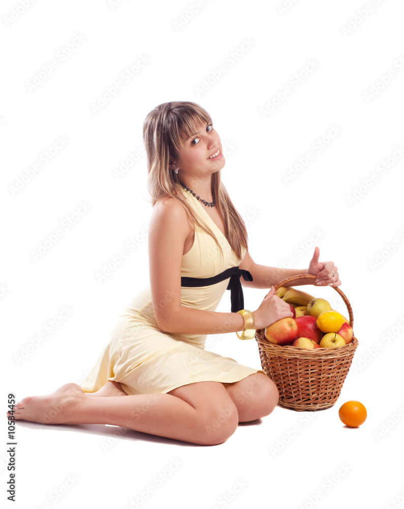 Girl in yellow dress sitting beside basket with fruit, isolated Girl in yellow dress sitting beside basket with fruit, isolated