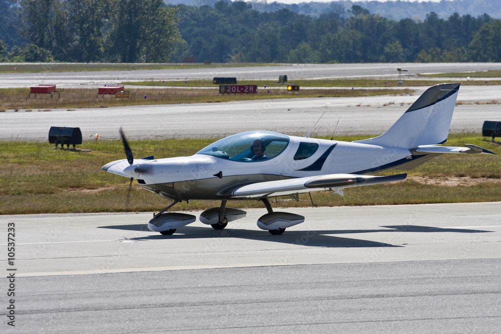 A small single prop plane taxiing across the runway A small single prop plane taxiing across the runway
