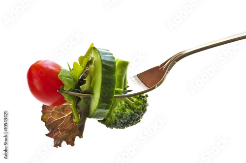 Fresh vegetables on a fork isolated on white background
