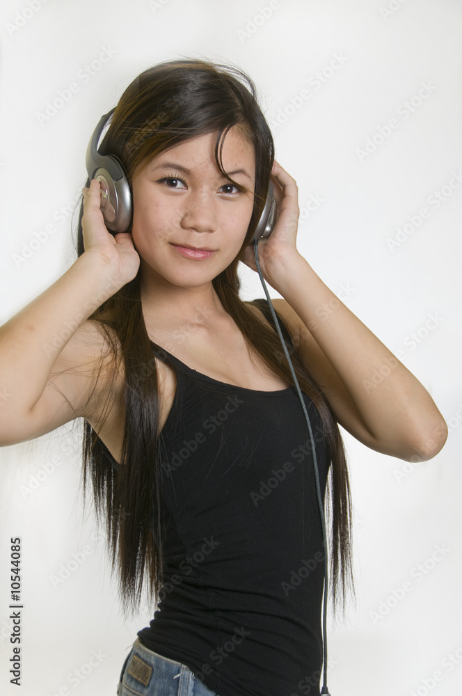 Naklejka premium Sexy young girl listening to music on headphones