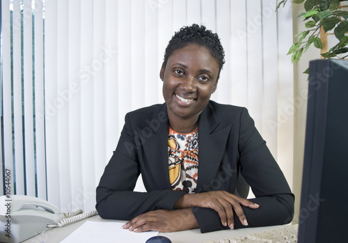 A lovely smiling Black woman in an office environment.