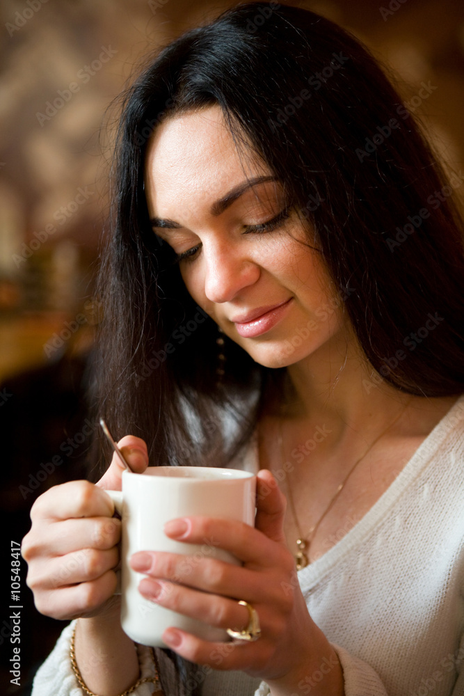 Beautiful young woman enjoying latte coffee in cafe. Beautiful young woman enjoying latte coffee in cafe.