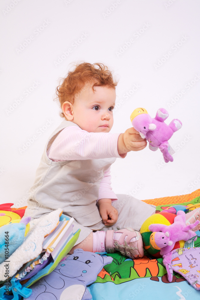 One year old red haired baby girl plays with toys. Studio Shot. One year old red haired baby girl plays with toys. Studio Shot.