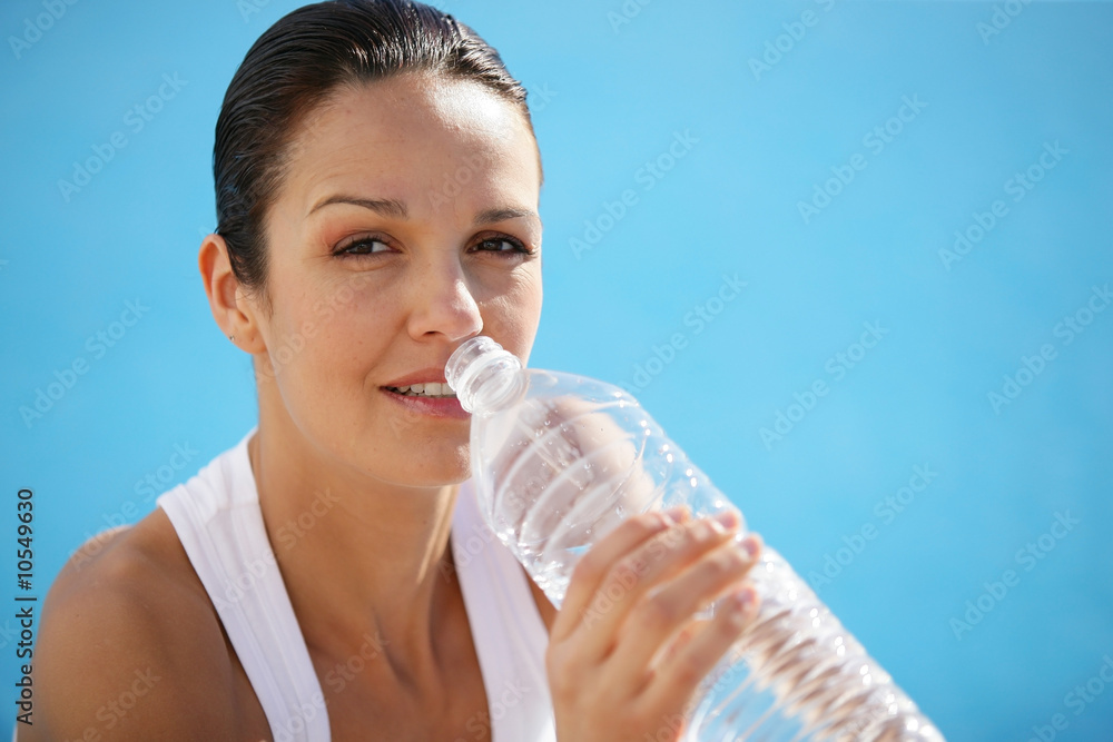 Portrait of a beautiful woman drinking from a bottle of water