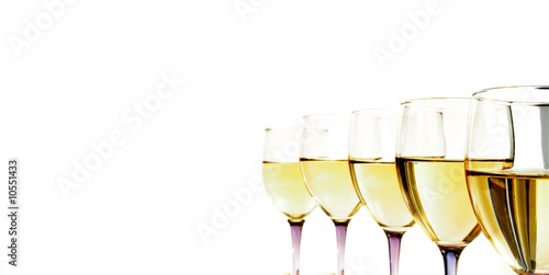 Closeup of white wine glasses and cork in a line, on white