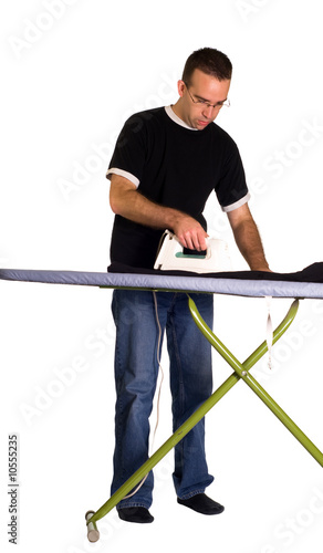 A young man with an iron pressing a pair of pants, isolated