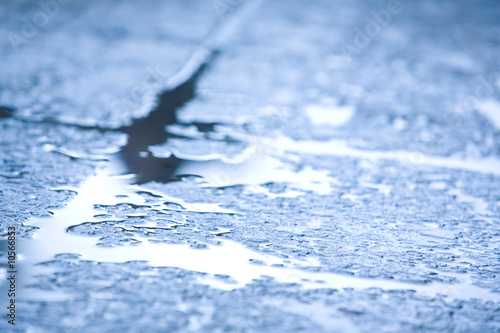 Macro image of blue wet surface of road after rain in autumn