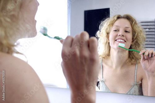 Donna allo specchio con spazzolino photo
