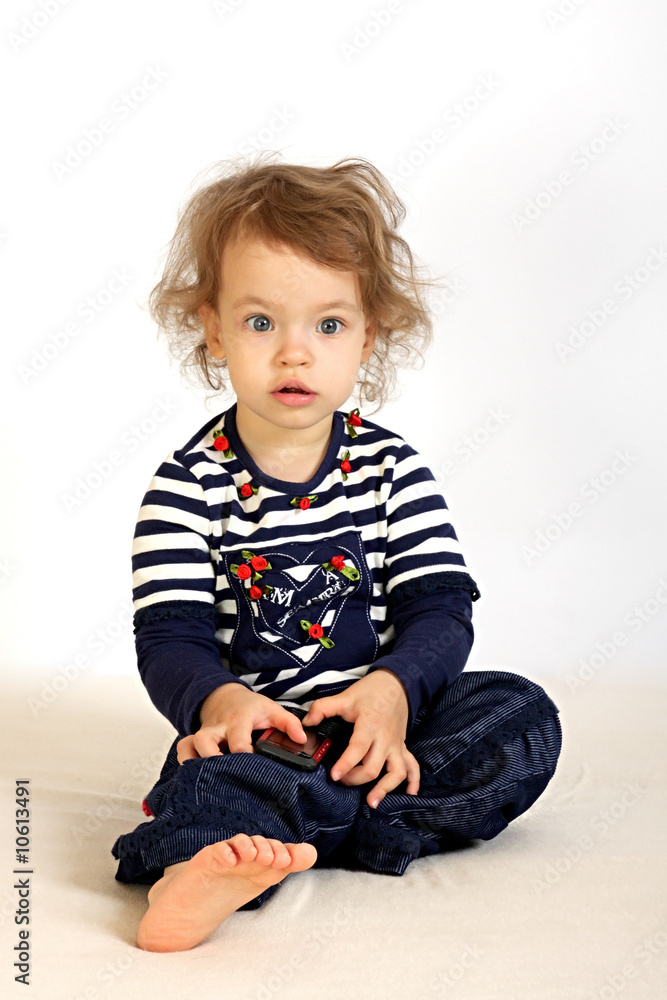 A little girl studies a telephone. A little girl studies a telephone.