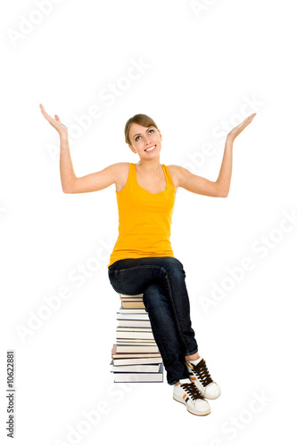 Young woman sitting on pile of books