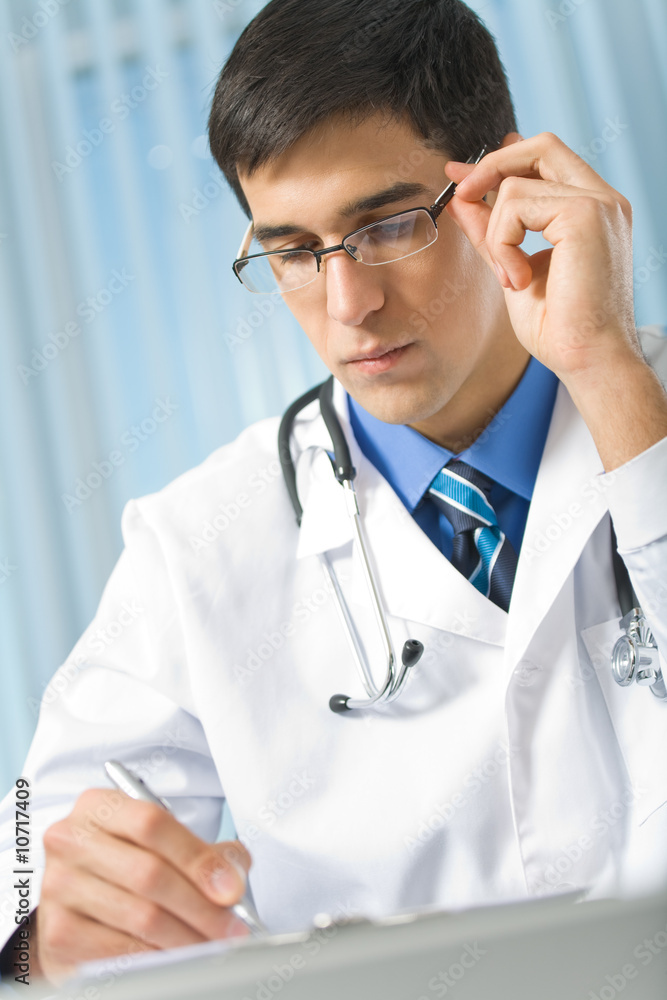 Doctor with stethoscope writing at office Doctor with stethoscope writing at office