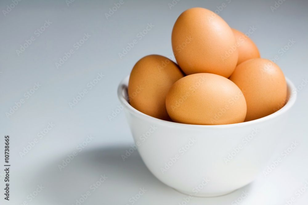 Fresh Brown Eggs In White Bowl on Blue-Grey Background Fresh Brown Eggs In White Bowl on Blue-Grey Background