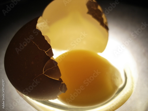 A bitten egg in a plate, downlighted photo