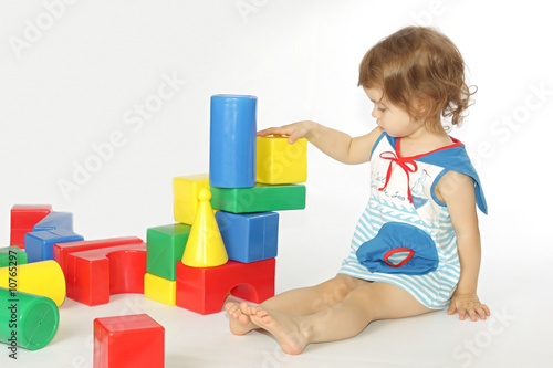 A little girl builds a house.