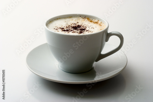 Ceramic mug with a cappuccino on light background